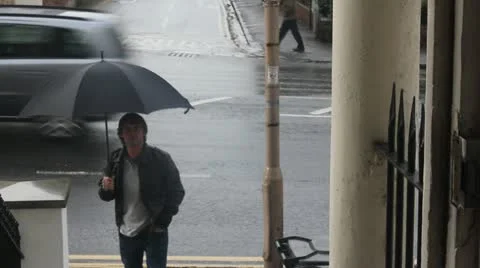 Man with umbrellar goes into apartment Stock Footage 10897476