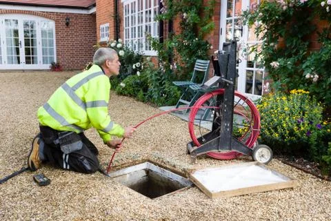 Man unblocking outside drain Stock Photos