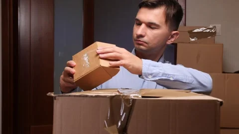 Man unboxing small parcel from large delivery package 스톡 동영상 318980190