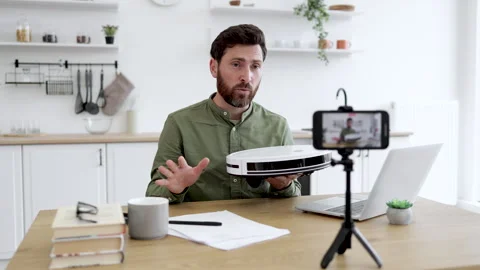 Man unboxing vacuum cleaner while recording video on mobile Stock Footage 253346499