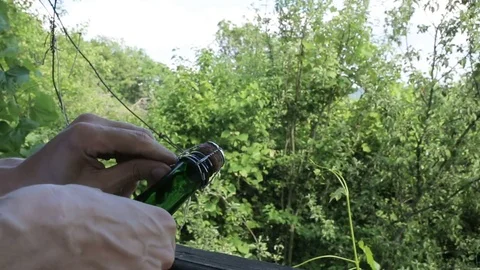 Man uncorking a bottle of champagne in the open air Stock Footage 76445869
