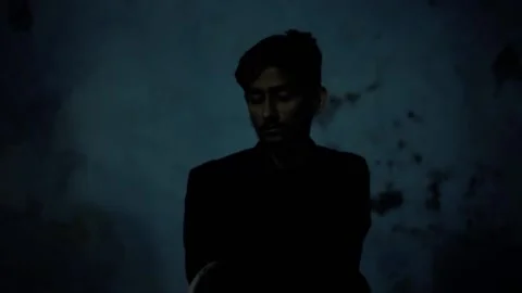 Man uncovering the face of another man (hostage) tied to a chair. Stock Footage 240010202
