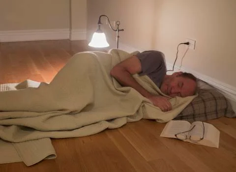 Man under blanket on floor Stock Photos
