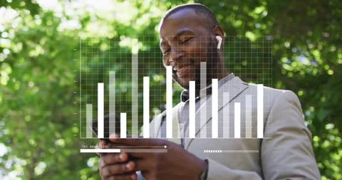 Man under tree tapping phone on ping, earbuds playing audio, chart showing Stock Footage 333901387