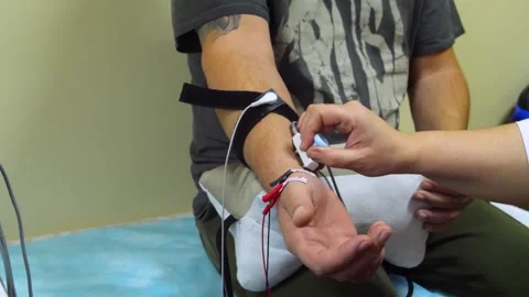 A man undergoes an examination on an electromyograph. Stock Footage 321609398