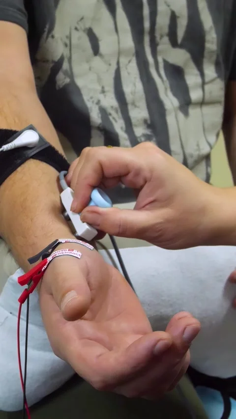A man undergoes an examination on an electromyograph - vertical video Video stock 321799523