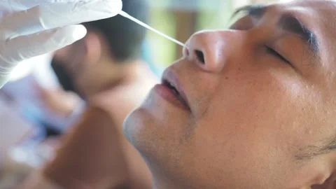 A man is undergoing a rapid antigen test, take a mucus sample from his nose Stock Footage 195583659