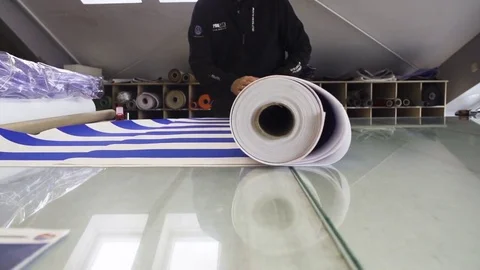 Man unfolding roll of striped sheet in slow motion Stock Footage 71566348