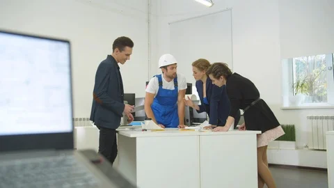 Man in uniform and group of engineers discuss schemes of houses Stock Footage 121813898