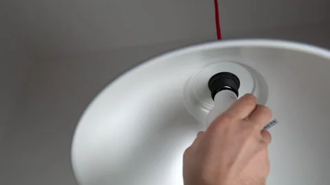 Man uninstalling light bulb from ceiling light Stock Footage 160812594