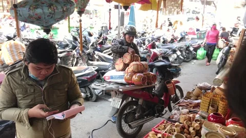 Man unloading bamboo crafts from his motorbike in a lantern shop in Da Nang Stock Footage 146766646