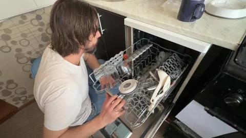Man unloading clean dishes from dishwasher at home. Overhead view of kitchen Stock Footage 335645616