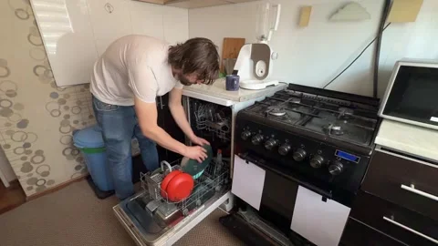 Man unloading clean dishes from dishwasher at home. Overhead view of kitchen Stock Footage 336980386