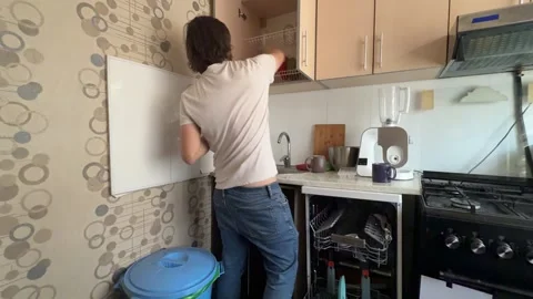 Man unloading clean dishes from dishwasher at home. Overhead view of kitchen Stock Footage 336980423