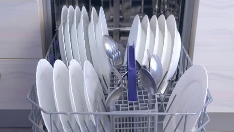 Man unloading dishwasher and taking out white utensil and cutlery from basket. Stock Footage 116819783