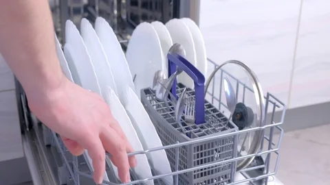 Man unloading dishwasher taking out white utensil and cutlery high speed. Stock Footage 116375829