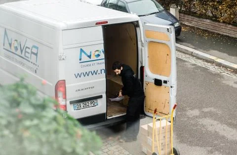 Man unloading goods from white delivery van Photos