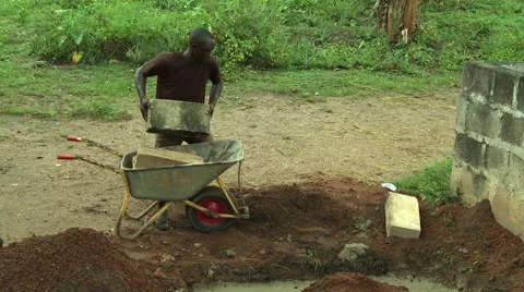 MAN UNLOADS WHEELBARROW Stock Footage 57983312