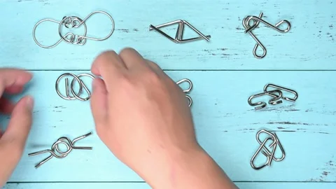 Man unlocking interlock steel hook puzzles Stock Footage 218379741