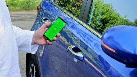 Man unlocks car door by using mobile application on smart phone. Concept of Stock Footage 157683191