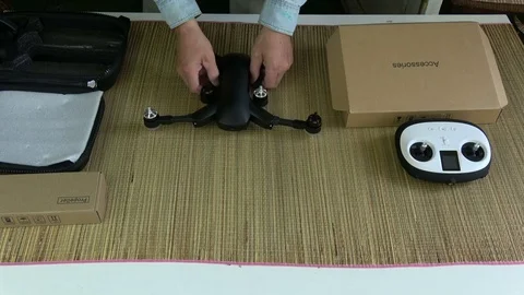 Man unpacking and looking construction new black drone quadcopter Stock Footage 78414929