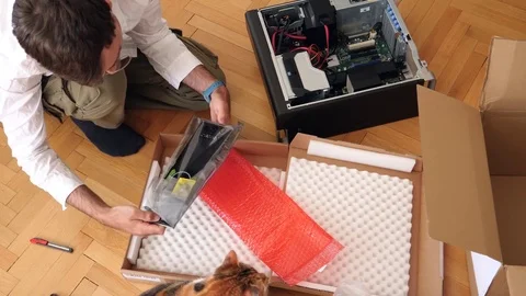 Man unpacking computer parts for upgrade of the Brocken computer dell parts Stock Footage 79242833