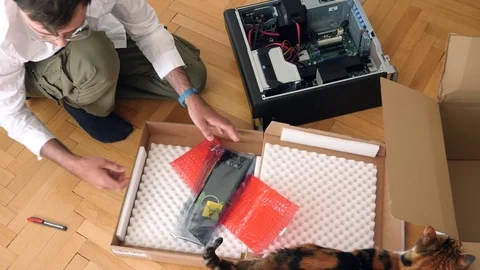 Man unpacking computer parts for upgrade of the Brocken computer dell parts Stock Footage 79243572