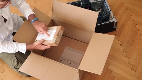 Man unpacking computer parts for upgrade of the Brocken computer dell parts Stock Footage 79248908