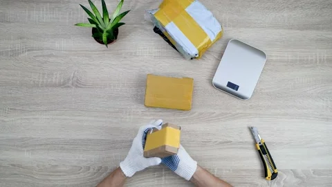 Man unpacking parcels from ordered online. Above view of man working on table Stock Footage 147078515