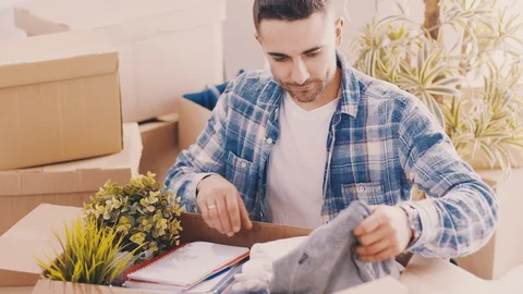 A Man Unpacks Boxes After Moving To A New Apartment Stock Footage 127948983