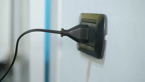 Man unplug electronic device in wall power plug at home,energy cost saving Stock Footage 168902929