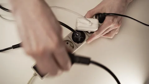 Man unplugging plugs from multiple socket saving electricity. Stock Footage 308809065