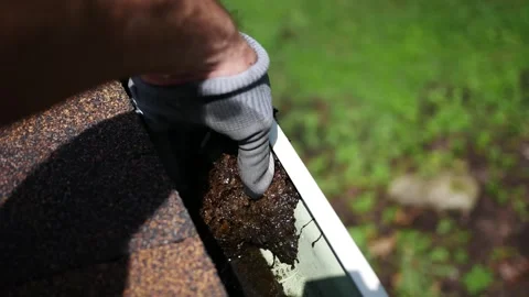 Man Unplugs Downspout in Clogged Gutter Stock Footage 340113405
