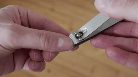 Man unprofessionally clipping his nails with a rough nail clipper Stock-Footage 149779042