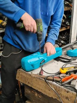 A man of unrecognizable appearance repairs an electrical appliance at home Stock Photos