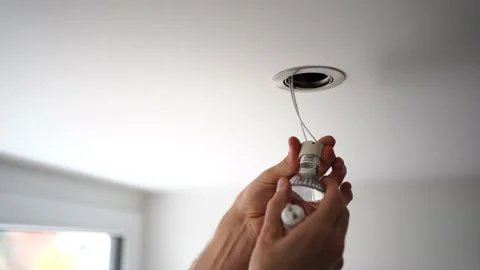 Man (unrecognizable) replacing a LED spotlight on a ceiling. Stock Footage 222824434