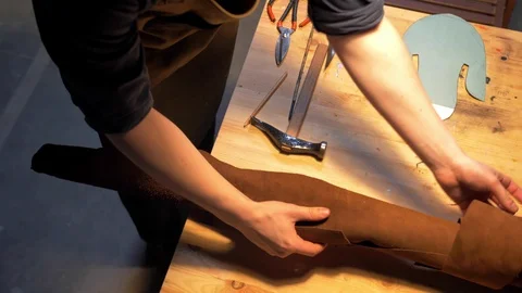Man unrolls fabric on table in workshop Stock Footage 126717527