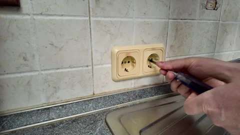 Man unscrewing old yellowed socket for replacement Stock Footage 312603072