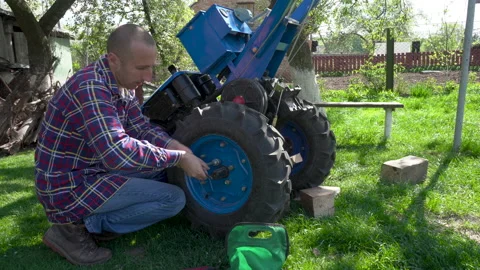 Man Unscrewing  tractor Wheel Stock Footage 147929973