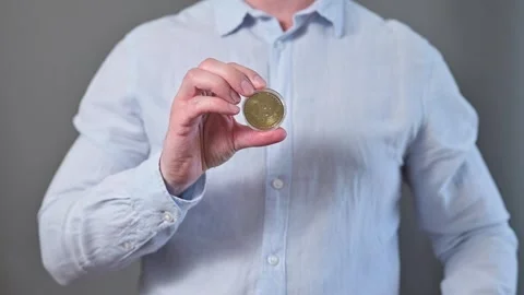 A man of unspecified age and race retrieves a coin from a wallet and holds it up Stock-Footage 338300150