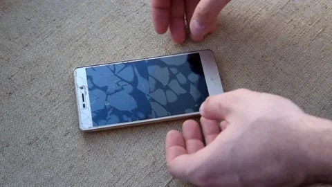 The man unstick the protective broken screen on the smartphone. Stock Footage 133763957