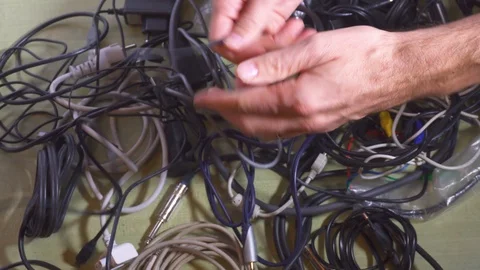 Man untangling tangled cables. Wireless concept. Close-up. Stock Footage 99917410