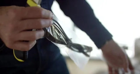 Man Unwrapping Small Product from Plastic Bag, Indoor, Close Up Shot Stock Footage 341326616