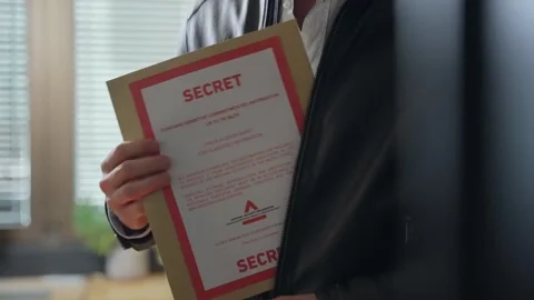 Man unzips leather jacket, discreetly pulling out a secret folder. Secrecy Stock Footage 305845408