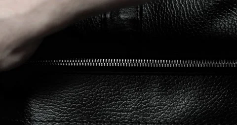 Man unzips metal zip testing it on a leather black bag, hand closeup view. Stock Footage 131065856