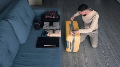 The man unzips the suitcase. Preparing for a vacation Stock Footage 275679604