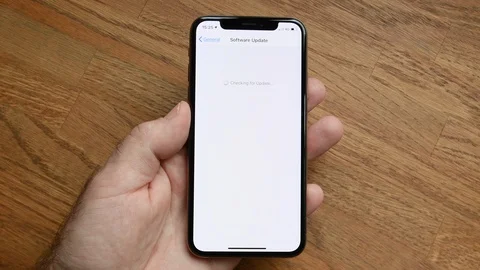 Man update latest iPhone XS Pro tablet to iOS software Stock Footage 105571315