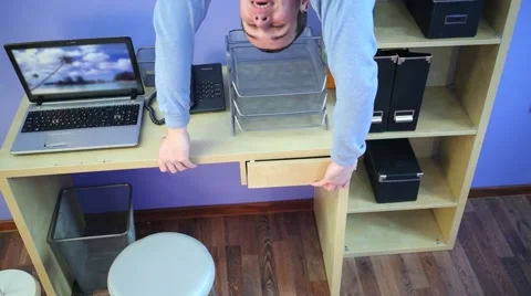 Man upside down opens desk drawer at inv... | Stock Video | Pond5