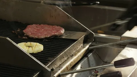 Man Upturning Meat on a Grill and Adding Cheese Stock Footage 71567962