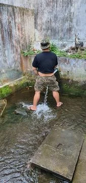 A man urinating in a river Stock Photos